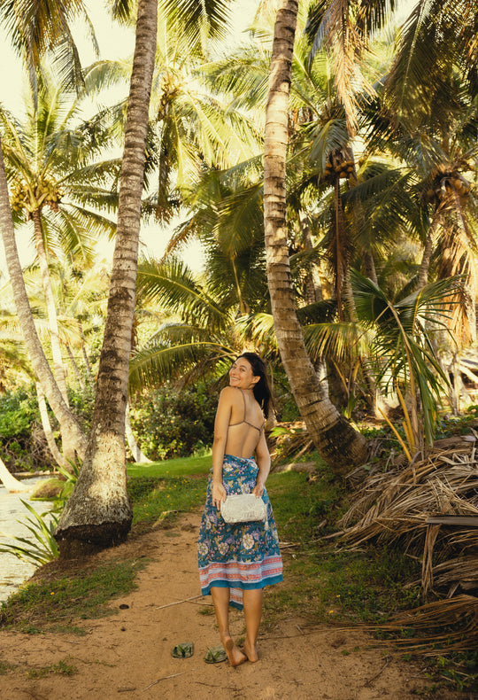 travel pouch held in a palm tree orchard